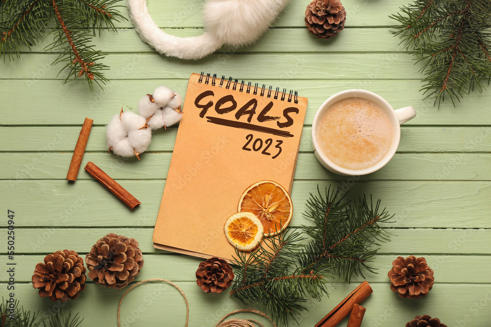 Notebook with blank to-do list for year 2023, Christmas decor and hot beverage on green wooden backg