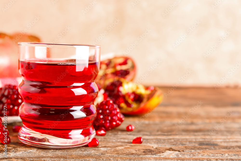 Glass of fresh pomegranate juice on wooden table