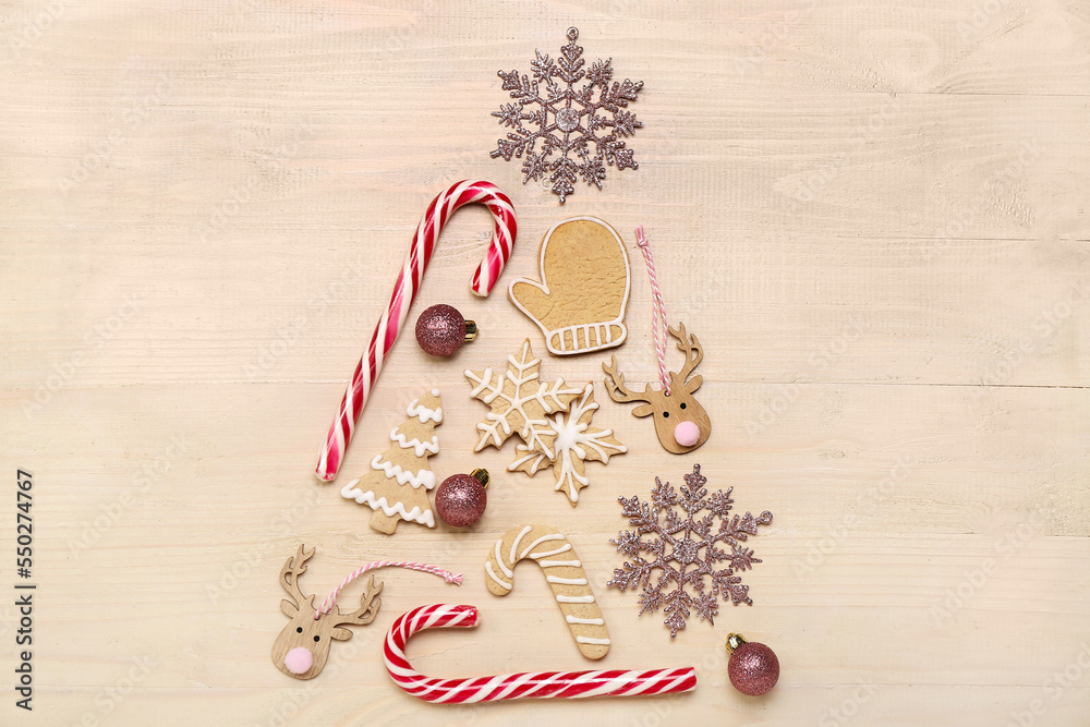 Christmas tree made of cookies, candy canes and decorations on wooden background