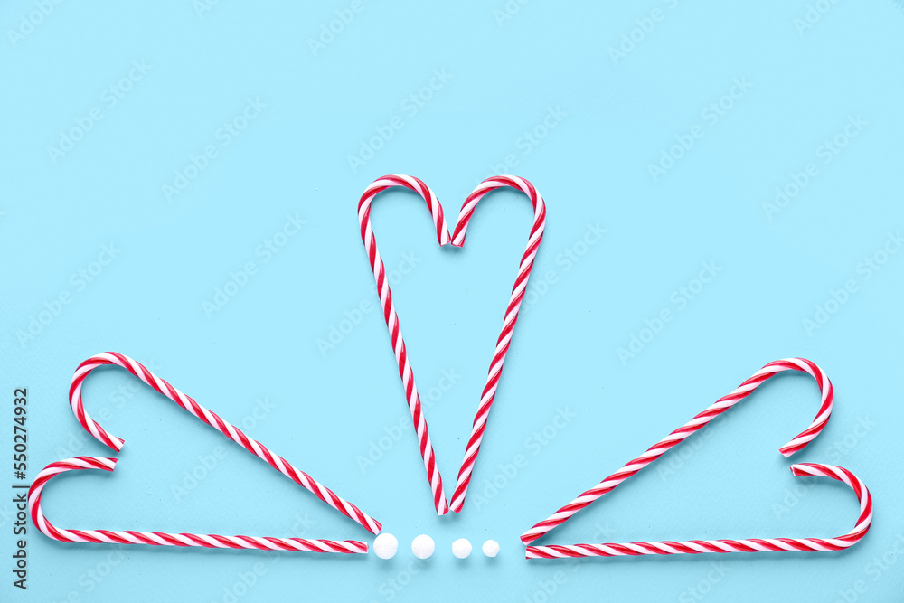 Composition with tasty candy canes on color background