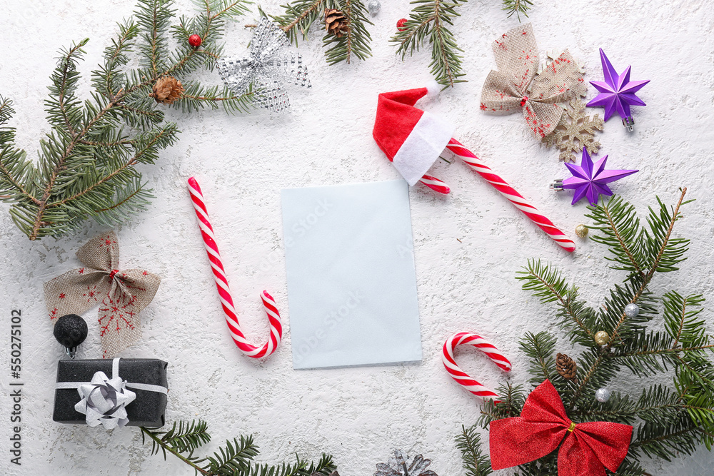 Composition with blank card, fir branches, Christmas decorations and candy canes on light background