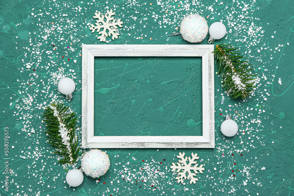 Composition with empty picture frame, fir branches, Christmas decorations and snow on color backgrou