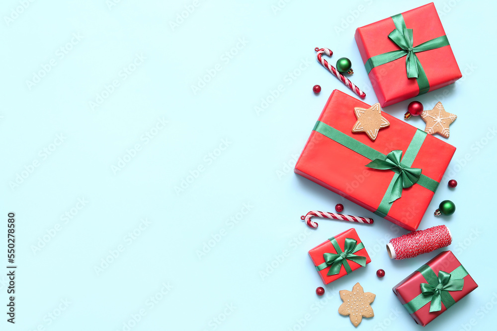 Gift boxes with Christmas decor and cookies on blue background