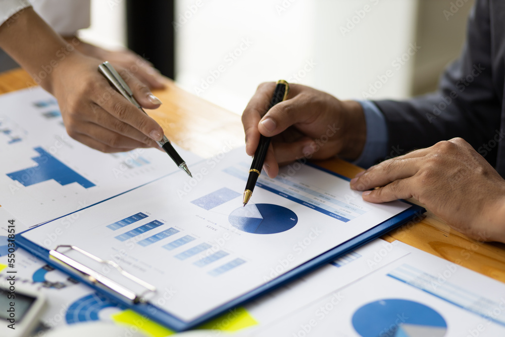 Business finance consultants discuss analysis of marketing reports to assess the profitability of th