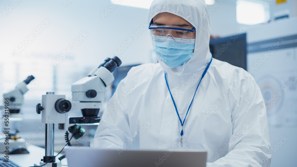 Modern Technology Concept: Engineer in Coverall Working on Laptop Computer. Electronic Manufacturing