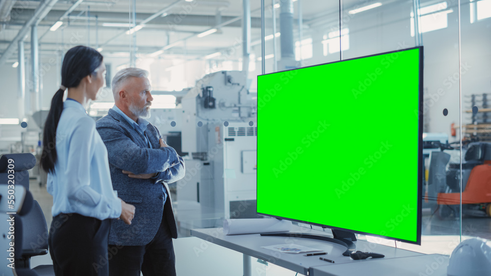 Factory Office Meeting: Chief Engineer Talking with Business Partner in a Conference Room with TV wi