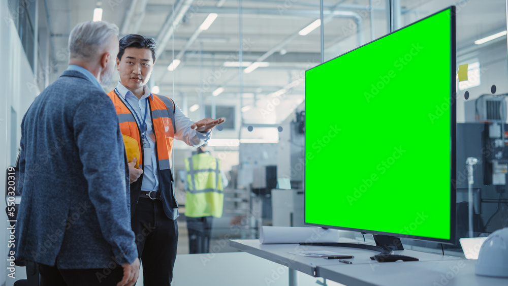 Factory Office Meeting: Chief Engineer Talking with Business Partner in a Conference Room with TV wi