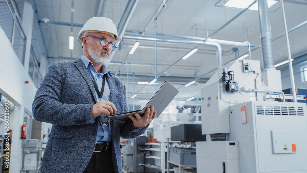 Portrait of a Bearded Middle Aged Chief Engineer Standing in a Factory Facility, Wearing Casual Suit