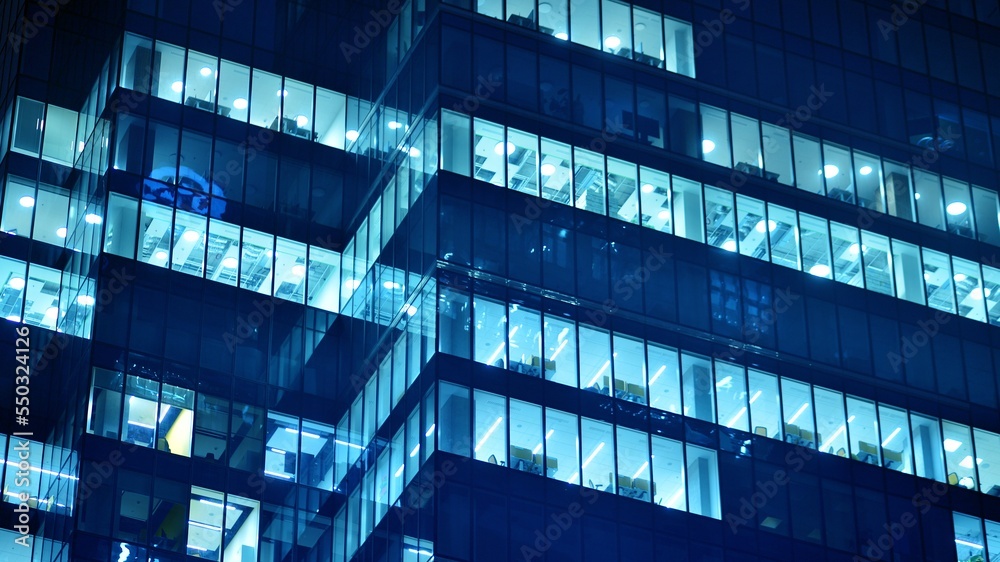 Pattern of office buildings windows illuminated at night. Glass architecture ,corporate building at 