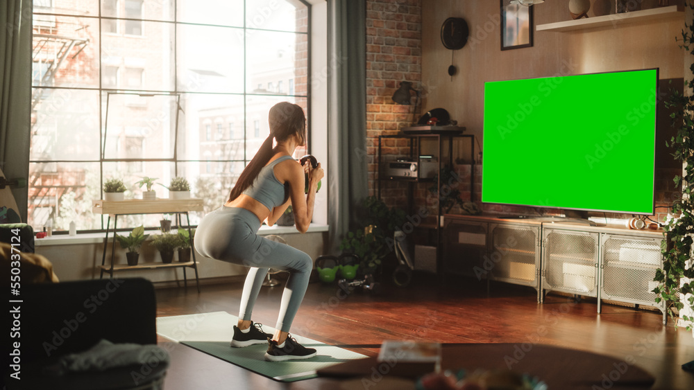 Active Girl Training at Home Using Green Mock-up TV Screen. Strong Athletic Fit Woman Using Technolo