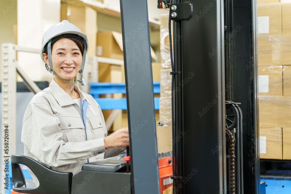 フォークリフトを運転する女性作業員のポートレート