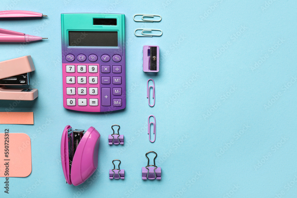 Set of different stationery with staplers on color background