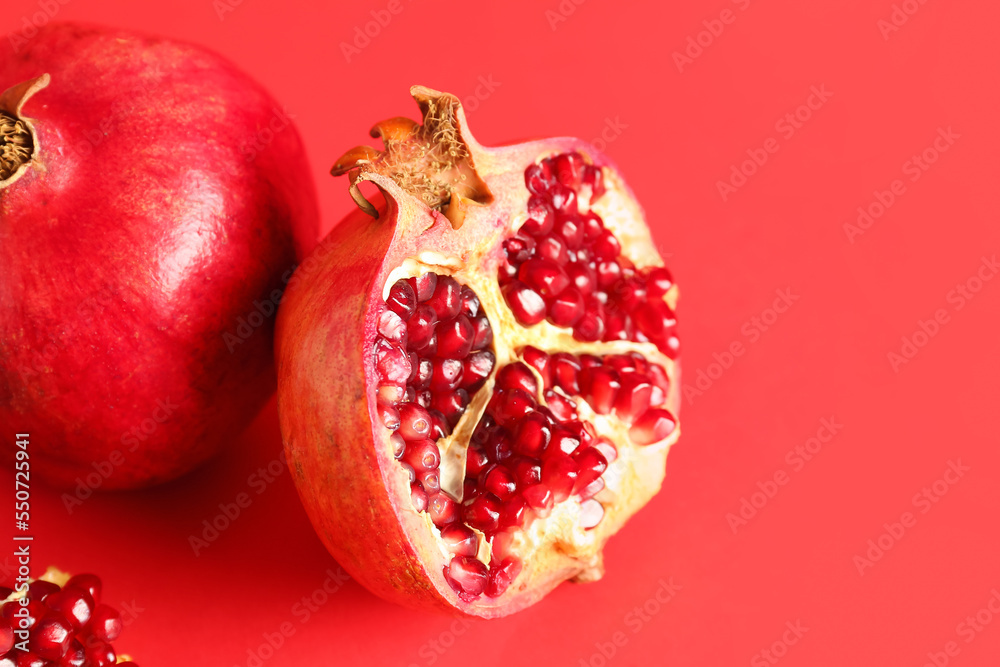 Fresh pomegranates on red background, closeup