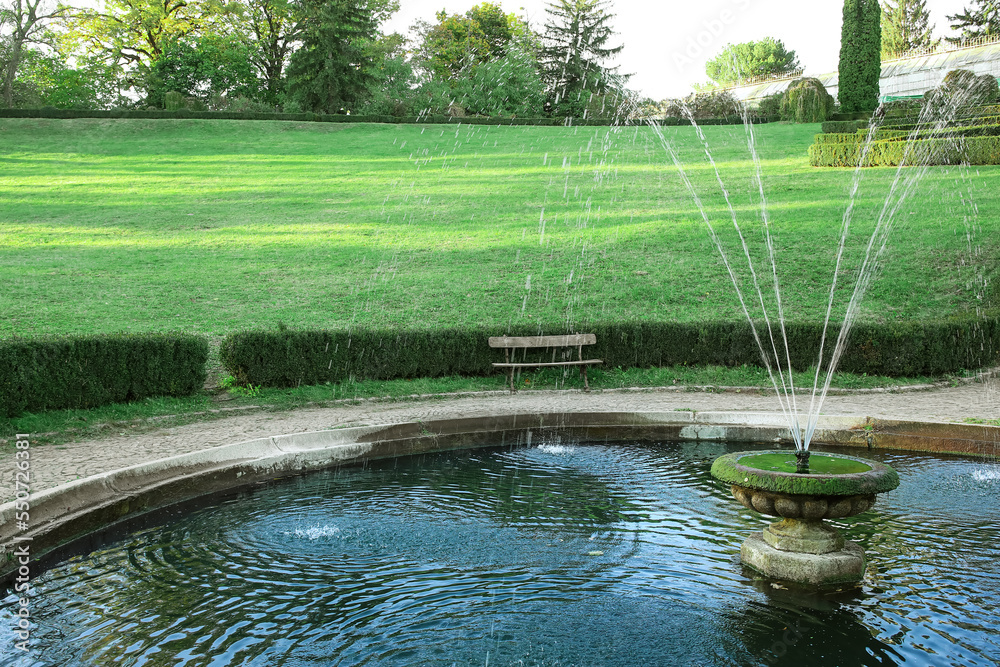 View of beautiful fountain and bench in park