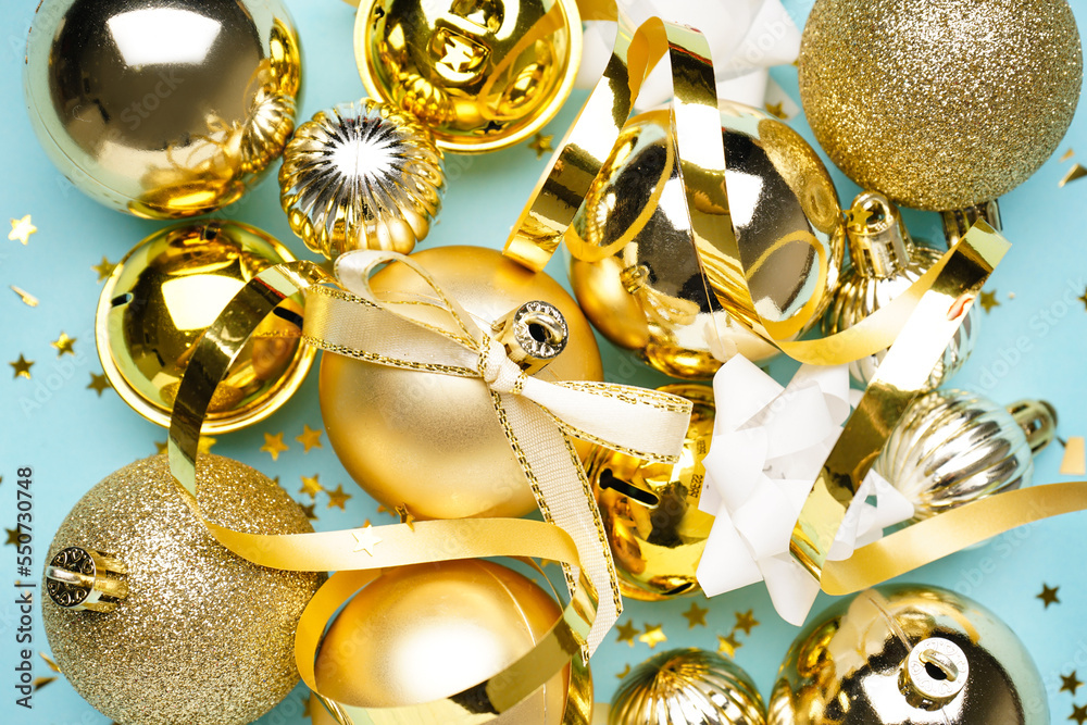 Golden Christmas balls with serpentine on blue background