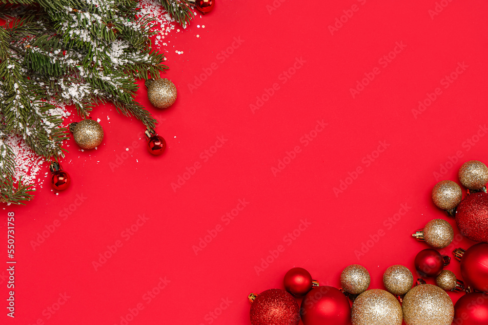 Frame made of Christmas balls, fir branches and snow on red background