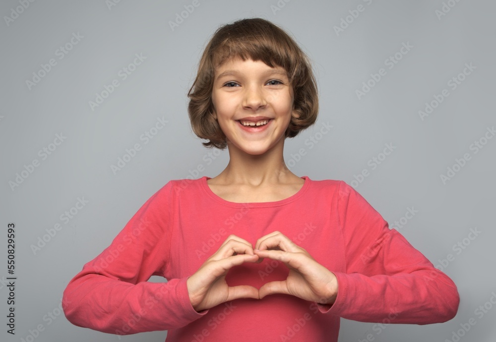 Portrait smiling girl baby showing her heart with her palms