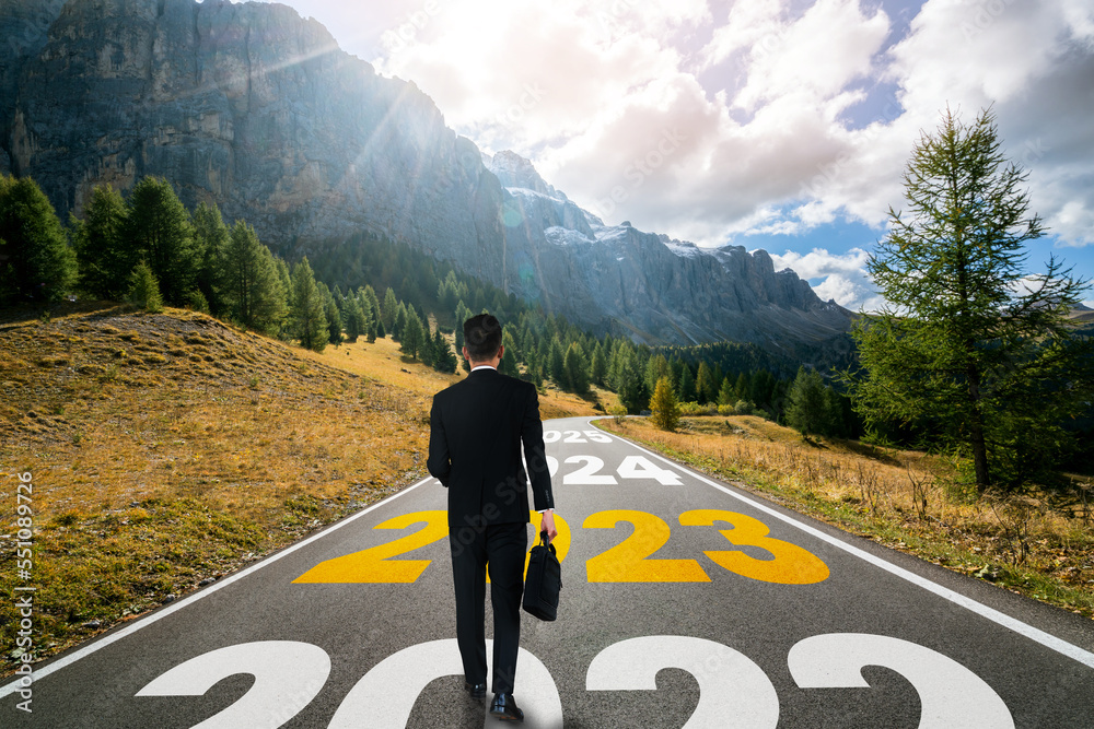 The 2023 New Year journey and future vision concept . Businessman traveling on highway road leading 