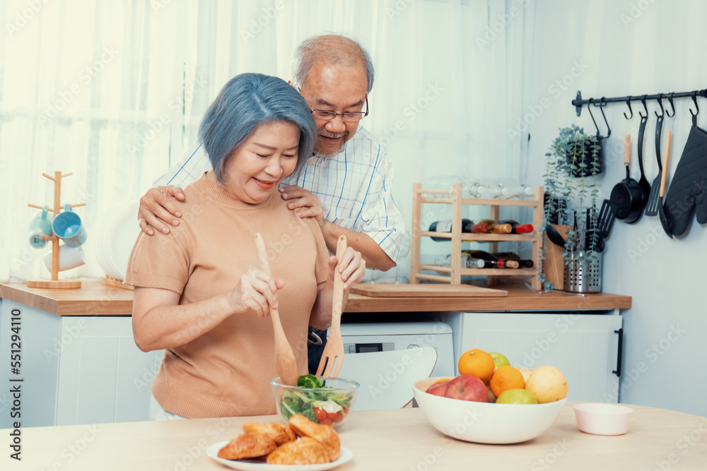 Contented senior couples who are happy to cook together with bread veggies and fruit in their kitche