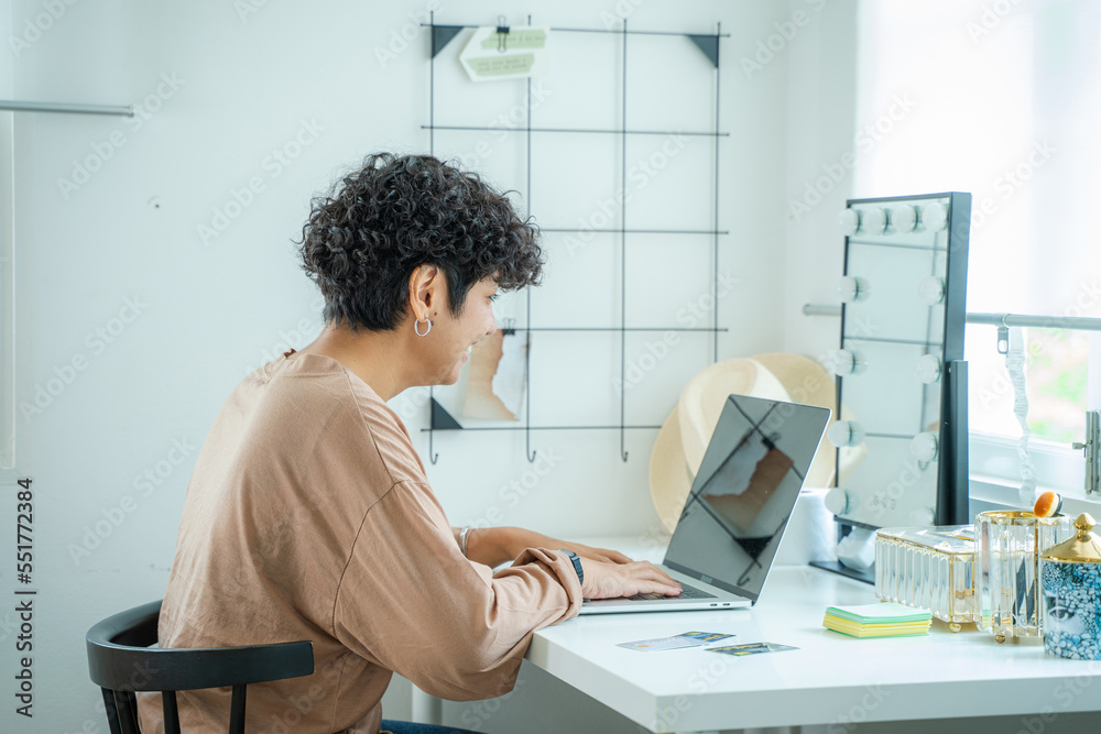 Young female reading publication via laptop computer making research for planning startup online sel