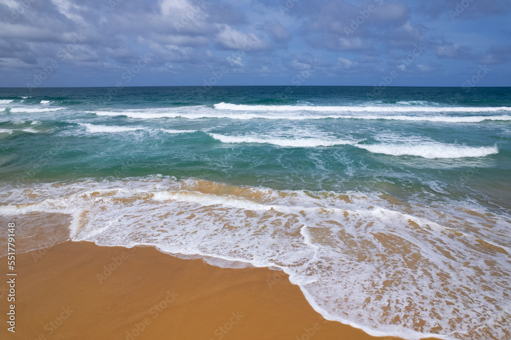 海浪冲击的鸟瞰图海滩沙滩上白沫滚滚的海浪，俯视海滩海景Na