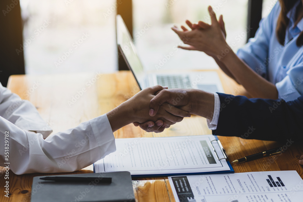 Handshake, manager is interviewing a new employee for a job. Collaboration of colleagues in the orga