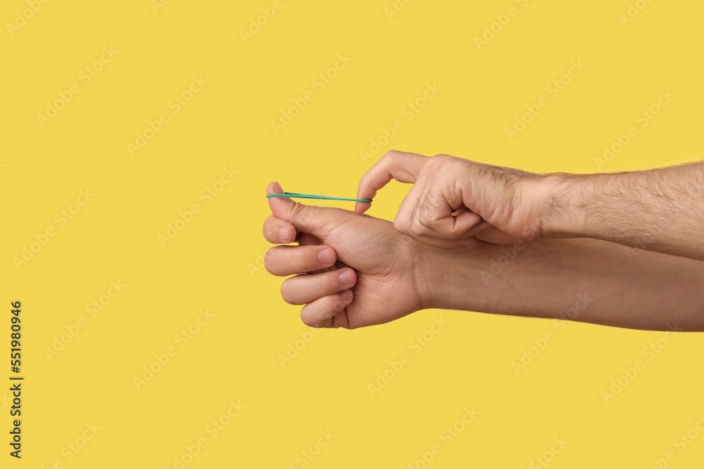 Man with green rubber band on yellow background