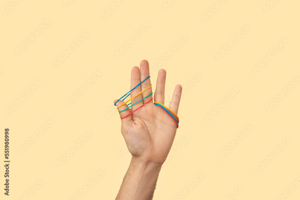 Man with rubber bands on beige background