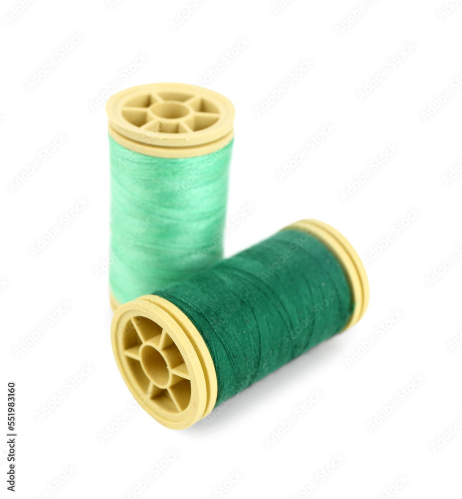 Green thread spools on white background