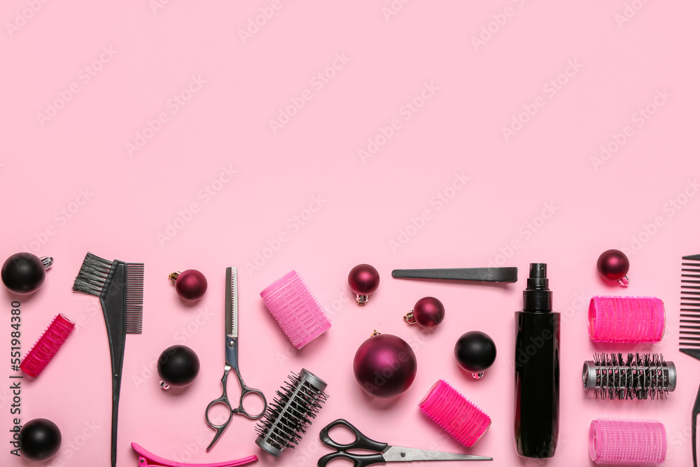 Hairdressers tools with Christmas balls on pink background