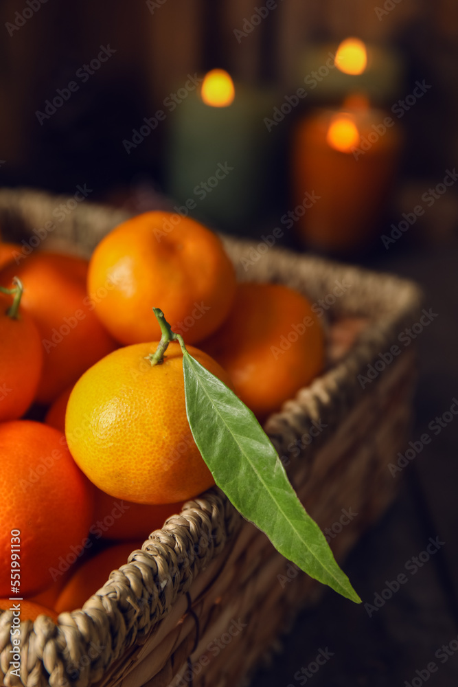 Basket with ripe tangerines on wooden table, closeup