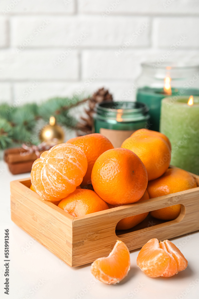 Wooden box with fresh ripe tangerines on table