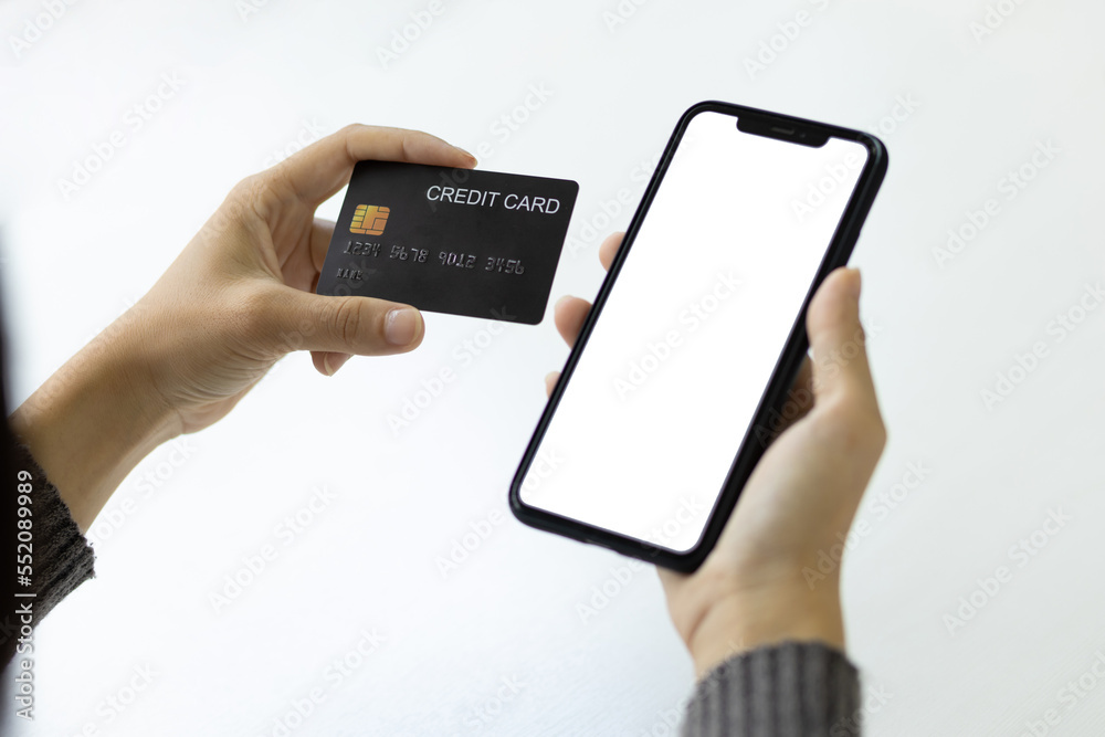 Close-up woman holding credit card using smart phone, Online shopping concept.