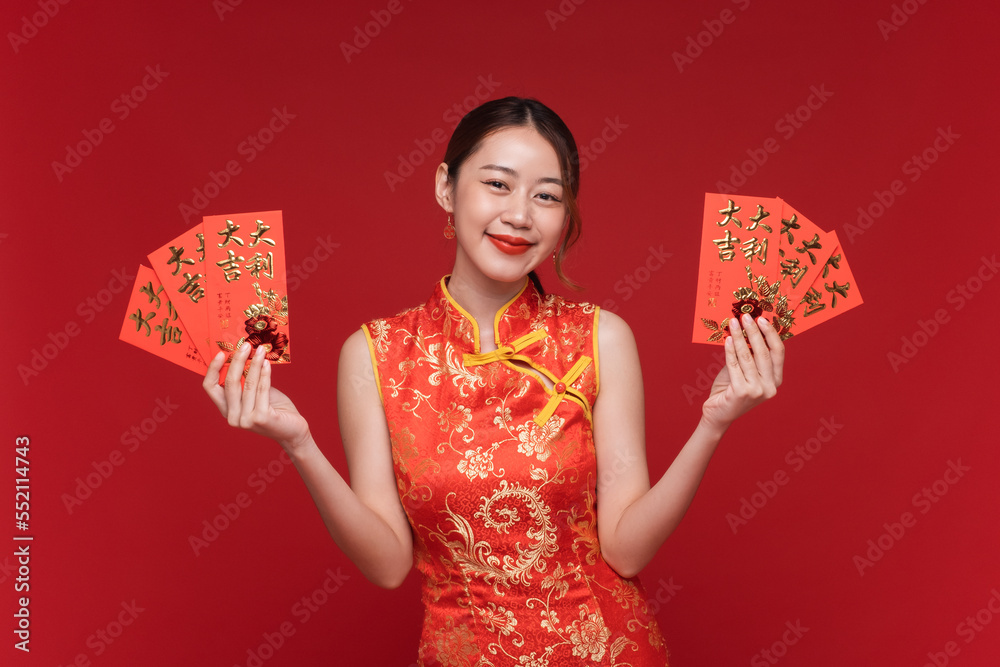 年轻的亚洲女性穿着红色背景的红色信封，为中国新年准备