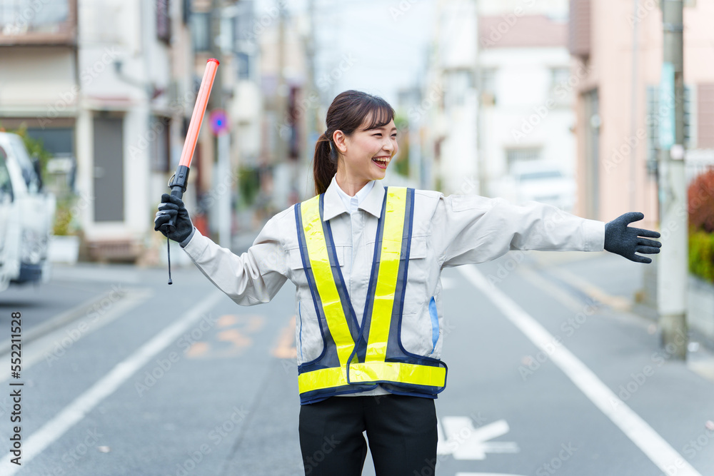 交通整理をする女性の警備員