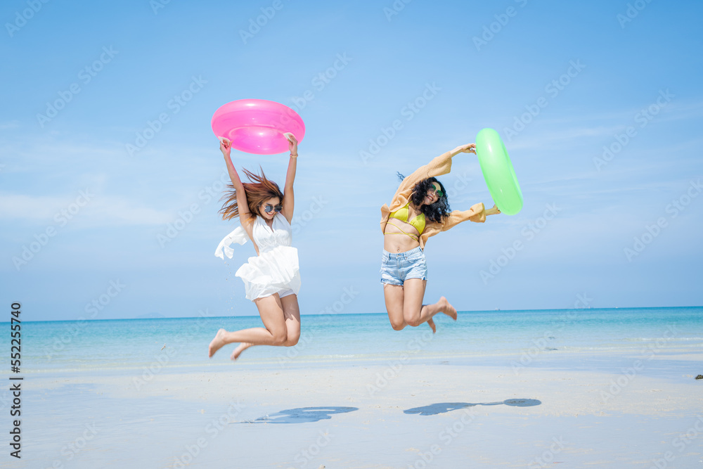 Two attractive girls jumping on the beach,Having Fun,Summer Lifestyle.