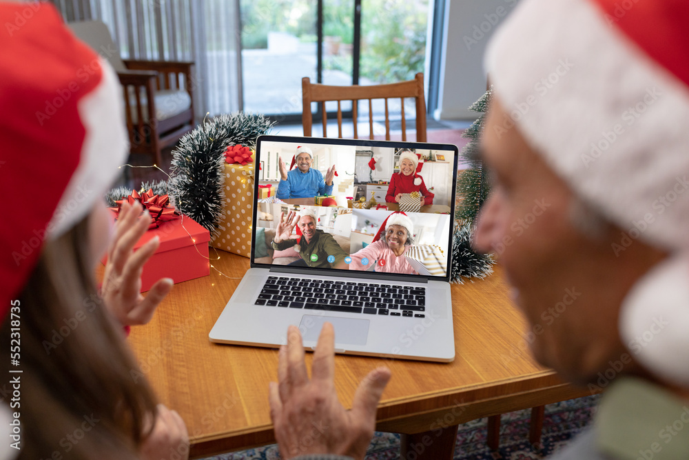 Caucasian father and daughter having christmas video call with diverse people