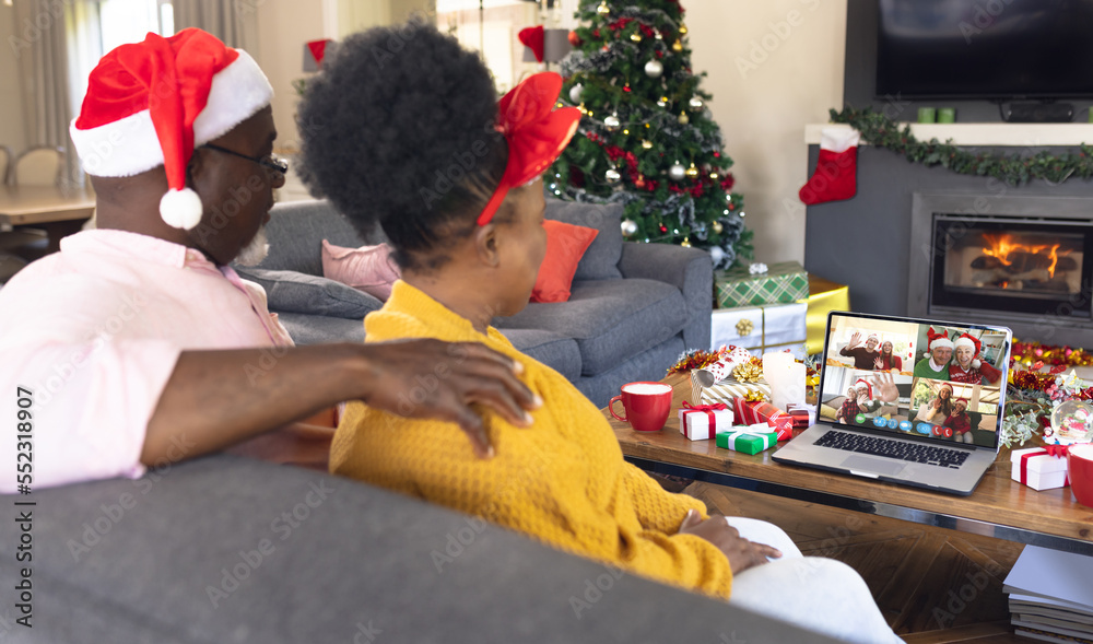 Senior african american couple having christmas video call with diverse people