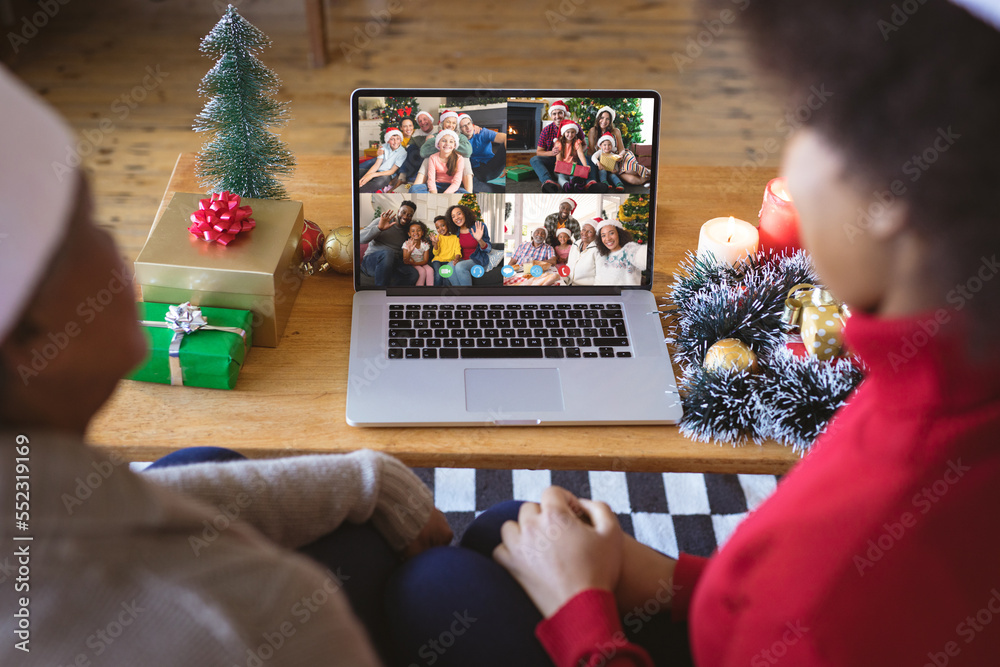 African american couple with santa hats having christmas video call with happy diverse families