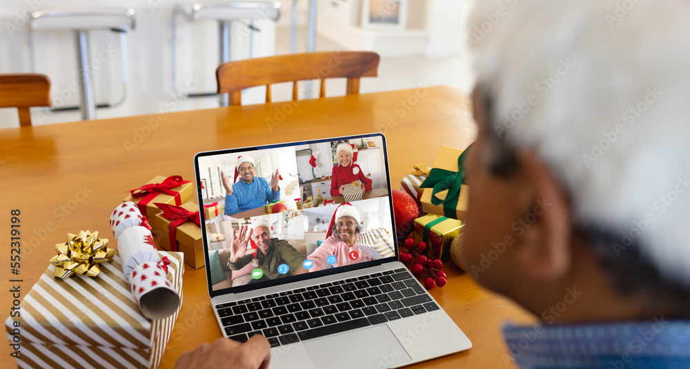 Biracial man with santa hat having video call with happy diverse friends