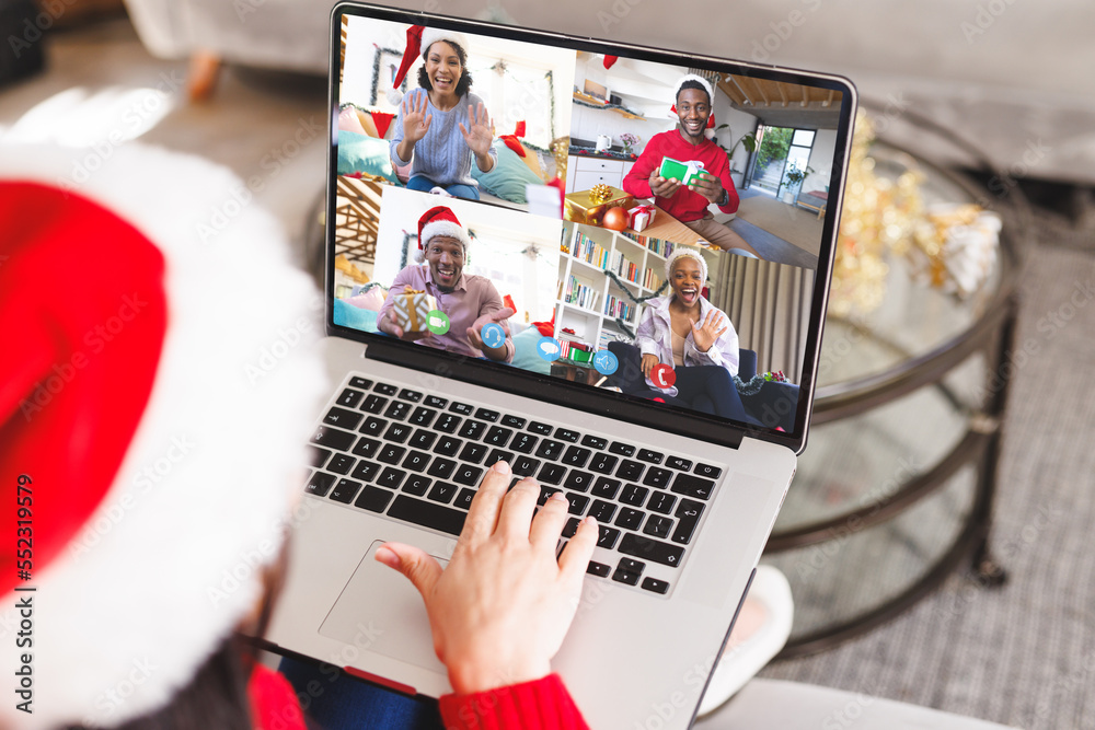 Caucasian woman with santa hat having video call with happy diverse friends