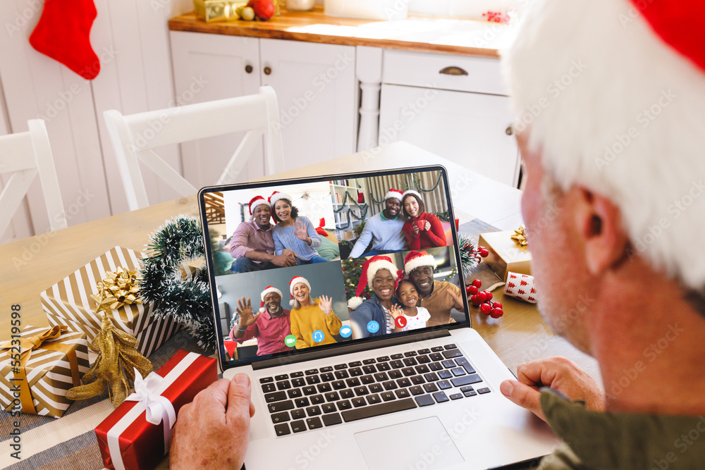 Caucasian man with santa hat having video call with happy diverse friends