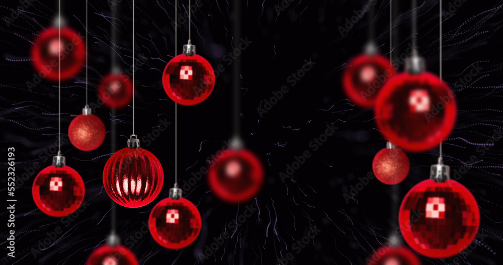 Image of fireworks over christmas baubles on black background