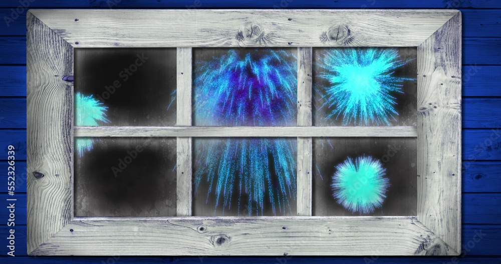 Image of window with blue christmas and new year fireworks in night sky