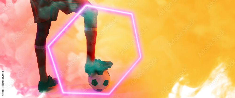 Low section of african american man with leg on ball by illuminated hexagon over smoky background