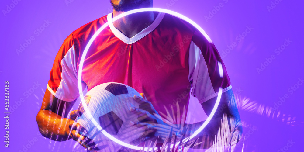 Midsection of african american male player holding ball with illuminated plants and circle