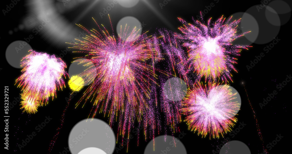 Image of colourful christmas and new year fireworks exploding in night sky with bokeh lights