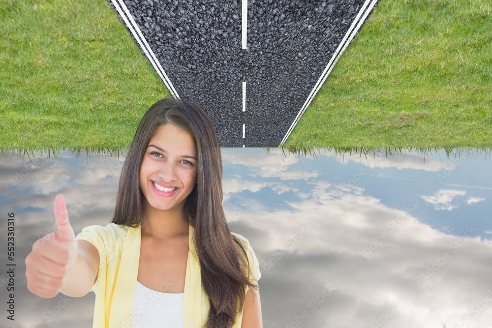 Caucasian woman showing thumbs up against upside down road and blue sky with copy space