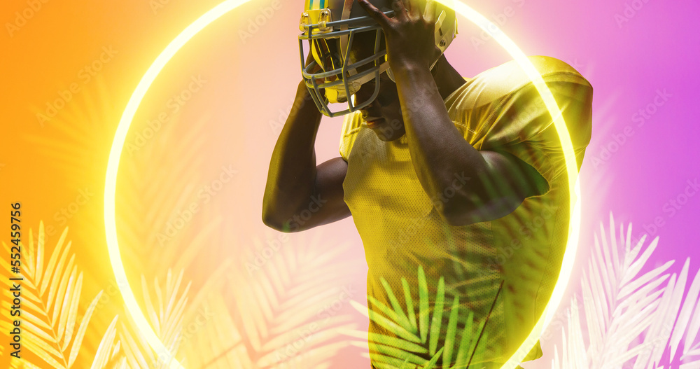 Composite of american football player removing helmet by illuminated circle and plants, copy space