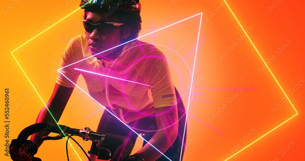 Biracial female cyclist wearing glasses and helmet riding bike over illuminated geometric shapes